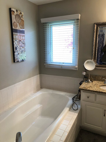 A before photo showing the old location of the dated bathtub before we remodeled this bathroom.