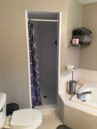 A before photo showing the old location of the shower in this bathroom remodel.