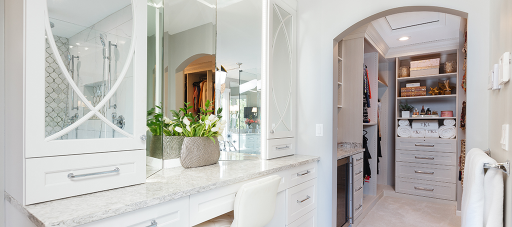 Elegant master suite vanity area with quartz countertop and entrance to walk-in closet.